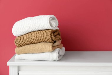 Pembe duvarın yanındaki klozette bir yığın kalın kazak.