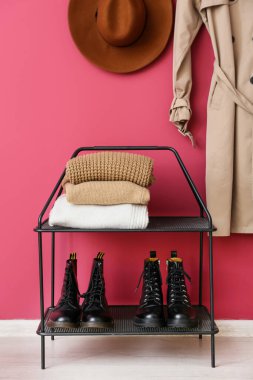 Pembe duvarın yanında kalın ve kalın kazaklar giyin.