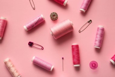 Renk arkaplanında iplik makaraları olan kompozisyon