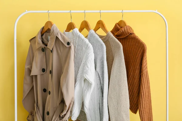 Rack Dengan Pakaian Hangat Gaya Dekat Dinding Kuning — Stok Foto