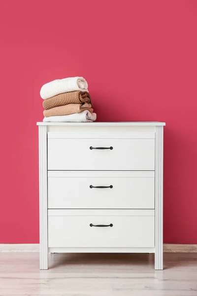 Stack Warm Sweaters Commode Pink Wall — Stock Photo, Image
