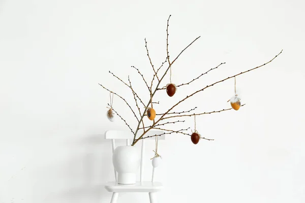 Vase Mit Ästen Und Ostereiern Auf Stuhl Neben Lichtwand — Stockfoto
