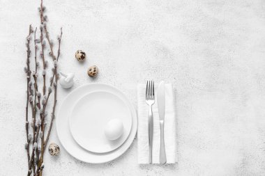 Paskalya tavşanı, bıldırcın yumurtası ve beyaz arka planda söğüt dallarıyla güzel bir masa.