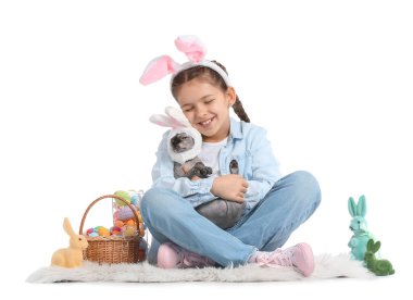 Beyaz arka planda Sphynx kedisi, Paskalya yumurtaları ve tavşanları olan küçük bir kız.