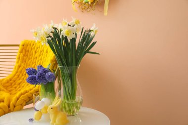 Paskalya dekoru ve renk duvarının yanındaki masada güzel çiçekler.