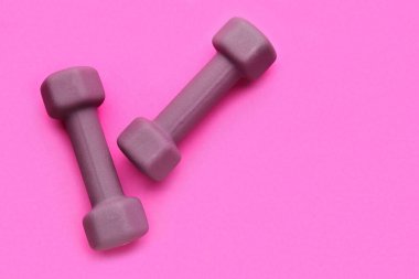 Pembe arka planda şık dambıllar