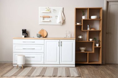 Ahşap raf ünitesi ve tahta tahtasıyla aydınlık mutfağın içinde.