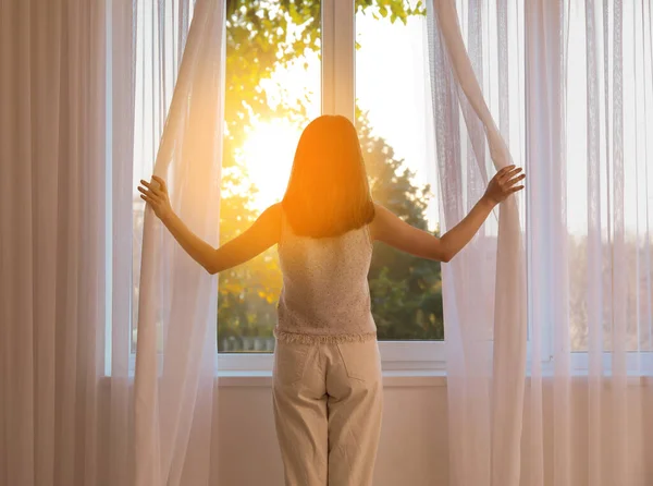 Mooie Jonge Vrouw Openen Gordijnen Kamer Zonnige Dag Achteraanzicht — Stockfoto