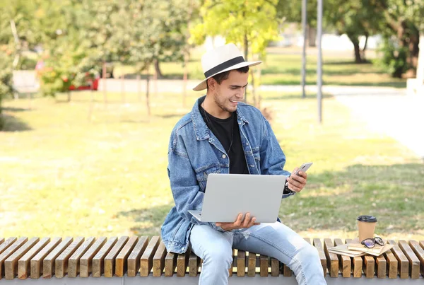 Bonito Homem Com Laptop Usando Telefone Celular Banco Parque — Fotografia de Stock