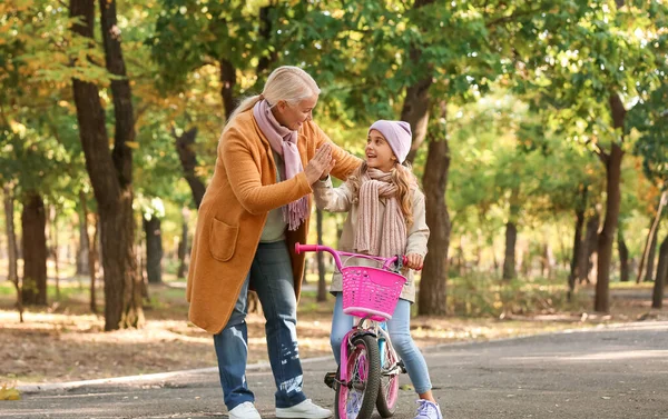 Bambina Con Bicicletta Dando Cinque Sua Nonna Nel Parco Autunnale — Foto Stock