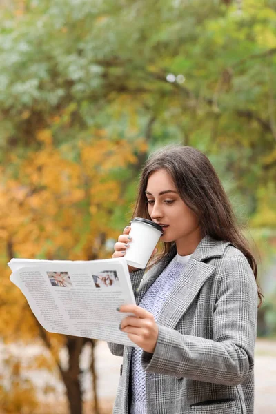 Piękna Młoda Kobieta Pije Kawę Czyta Gazetę Jesiennym Parku — Zdjęcie stockowe