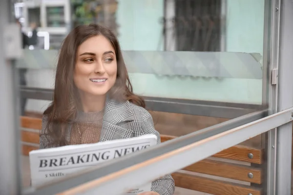 Hermosa Joven Con Periódico Sentado Parada Autobús — Foto de Stock