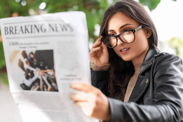 眼鏡の若い女性は屋外新聞を読んで — ストック写真