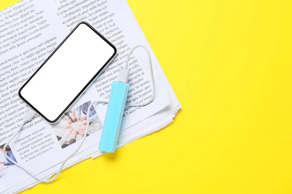 Power Bank Usb Cable Smartphone Newspaper Yellow Background — Stock Photo, Image