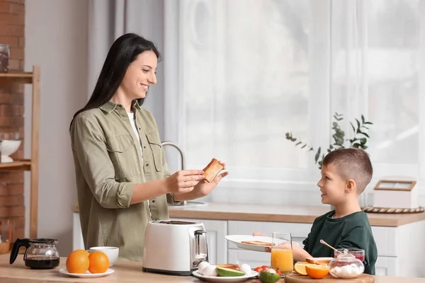 Little Boy His Mother Putting Toasted Bread Slices Plate Kitchen — Stock Photo, Image