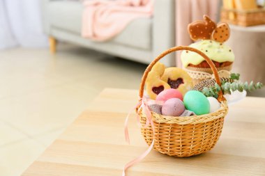 Odada boyanmış Paskalya yumurtaları ve kurabiyelerle hediye sepeti.