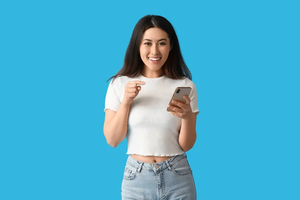 Šťastná Mladá Asijská Žena Mobilním Telefonem Modrém Pozadí — Stock fotografie