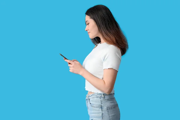 漂亮的年轻亚洲女人 蓝色背景的手机 — 图库照片