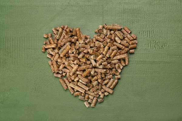 Corazón Hecho Pellets Madera Sobre Fondo Madera Verde — Foto de Stock