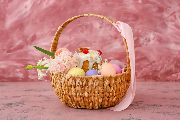 ピンクの背景にイースターの卵 花やケーキを描いたギフトバスケット — ストック写真