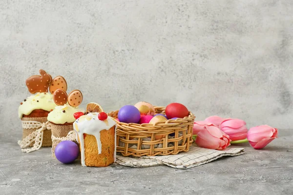 Καλάθι Δώρου Ζωγραφισμένα Πασχαλινά Αυγά Τουλίπες Και Κέικ Στο Τραπέζι — Φωτογραφία Αρχείου
