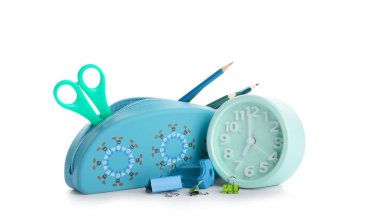 Beyaz arkaplanda alarm saati olan bir kırtasiye seti