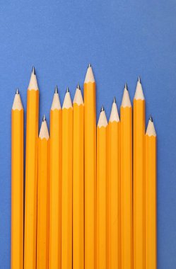 Mavi arkaplanda birçok sıradan kalem, yakın plan