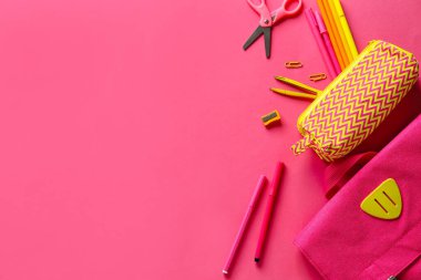 Kalem kutusu ve pembe arkaplanda farklı kırtasiye malzemesi