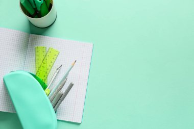 Turkuaz arka planda kırtasiye malzemesi olan kalem kutusu