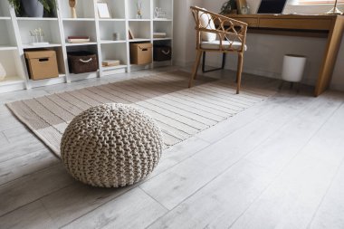 İçinde puf ve halı olan bir oda.