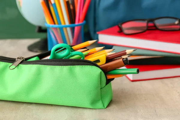 教室のテーブルの上の文房具と緑の鉛筆ケース クローズアップ — ストック写真