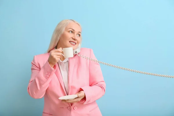 Volwassen Secretaresse Met Kopje Koffie Praten Telefoon Blauwe Achtergrond — Stockfoto