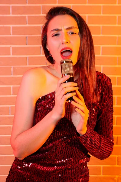 Pen Ung Syngende Kvinne Med Mikrofon Farget Mursteinsbakgrunn – stockfoto