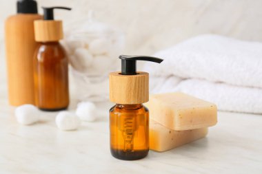 Hafif arka planda gerekli yağ ve sabun şişesi, yakın plan.