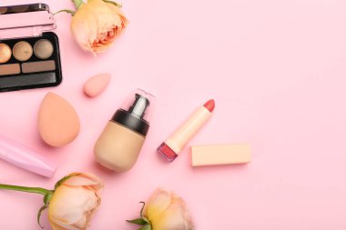 Dekoratif kozmetik ürünleri ve pembe arka planda gül çiçekleri