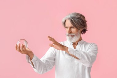 Arkaplanda kristal küresi olan olgun bir adam
