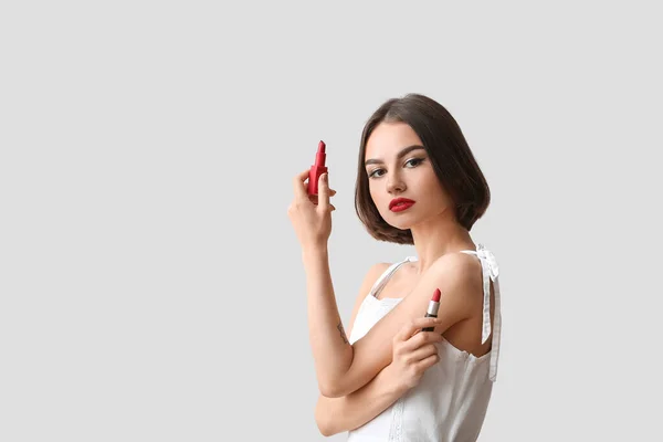 Νεαρή Γυναίκα Κρατώντας Κόκκινα Κραγιόν Στο Φως Φόντο — Φωτογραφία Αρχείου