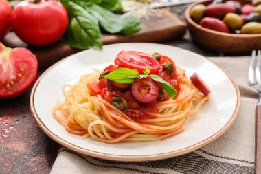 Pasta Puttanesca ve fesleğenli tabak, yakın plan.