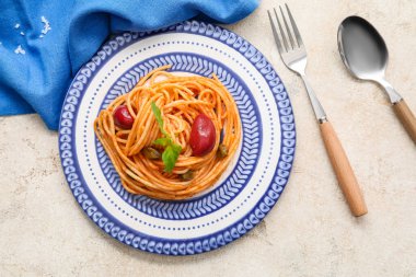 Hafif arka planda lezzetli Puttanesca makarnalı tabak.