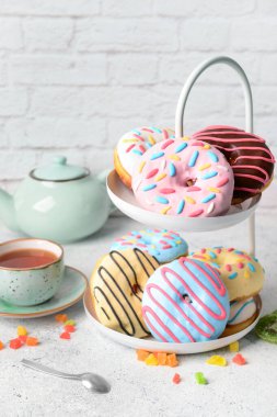 Lezzetli çörekler ve hafif arka planda bir fincan çayla ayakta durun.