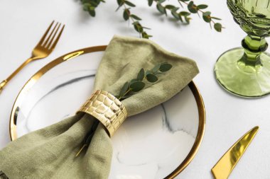 Açık arkaplanda yeşil dalı olan basit tablo ayarı, yakın plan