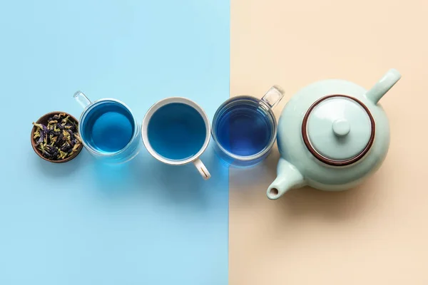 Tassen Mit Blauem Tee Und Getrockneten Schmetterlingserbsenblüten Auf Farbigem Hintergrund — Stockfoto