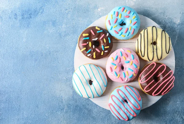 Board Mit Verschiedenen Leckeren Donuts Auf Farbigem Hintergrund — Stockfoto