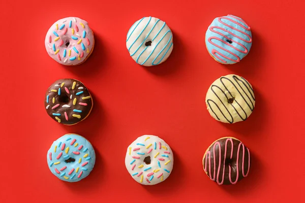 Rahmen Aus Verschiedenen Süßen Donuts Auf Rotem Hintergrund — Stockfoto