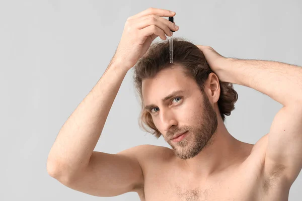 Hombre Joven Usando Suero Para Crecimiento Del Cabello Sobre Fondo — Foto de Stock