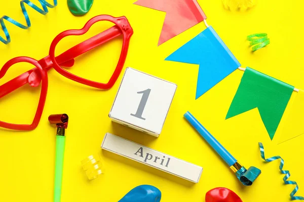 カレンダー4月の愚か者の日と黄色の背景にパーティーの装飾 — ストック写真