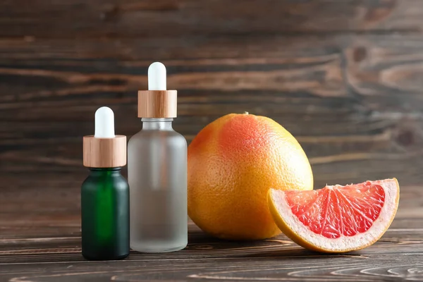 Bottles Essential Oil Ripe Grapefruit Wooden Background — Stock Photo, Image