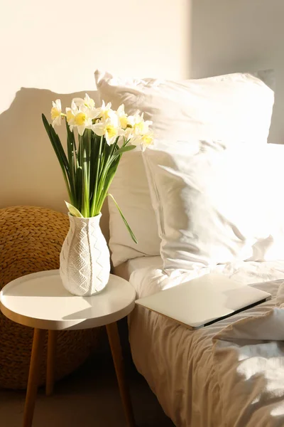 Vaseとともに新鮮なナルシシズム花上のテーブルで居心地の良いベッドルーム — ストック写真