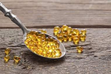 Ahşap arka planda jel haplı kaşık