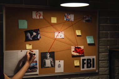 Dedektif FBI ajanının ofisinde kanıt inceliyor.